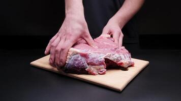 Close up of unrecognizable man's hands massaging and kneading raw meat of large beef steak before cooking video