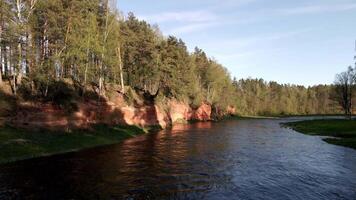 River Flowing by Red Sandstone Cliffs with Forested Top video