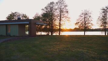 Modern Building and Leafless Trees at Sunset with Water Background video