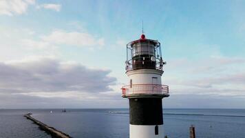 Lighthouse with Red Top and White Base on Coastal Breakwater video