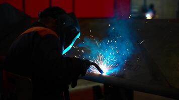 Welder at Work with Sparks and Blue Glow in Dimly Lit Workshop video