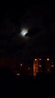 full moon in the night sky above high-rise buildings illuminated by lanterns video