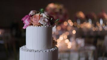 Elegant Two-Tiered White Cake with Pink and Peach Roses in a Festive Setting video