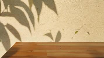 Blurred tree branch shadows on a wooden tabletop with a warm beige background. Minimalistic nature design. video