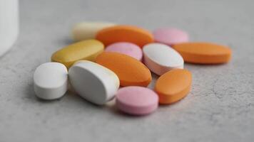 A Variety of Assorted Tablets and Capsules Positioned on a Gray Surface video