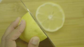 Slicing a fresh lemon on a sturdy wooden cutting board for cooking video