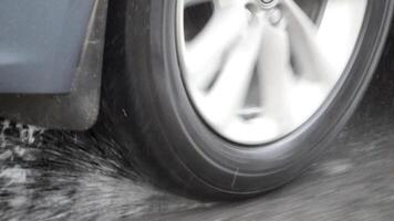 A Car Tire Making a Splash as it Passes Through Water on a Rainy Road video