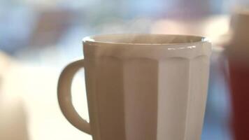 A steaming white mug rests on a bright background, creating a vivid scene video