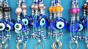 a bunch of blue evil eye keychains hanging on a shelf video