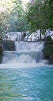 Scenic cascade waterfalls with blue water in natural pool in Central Sulawesi, vertical view video