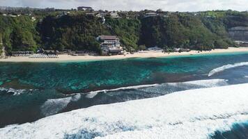 Scenic landscape with cliff coastline and beach with blue ocean and waves. Aerial view Bali shoreline with Melasti beach video