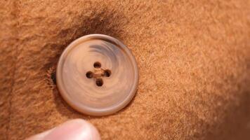 A Detailed CloseUp Image of a Button on a Brown Fabric Garment Item video