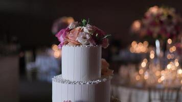 Elegant Two-Tiered White Cake with Pink and Peach Roses in a Festive Setting video