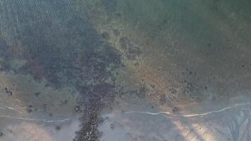 Tranquil Ocean Scene with Rocky Islands and Boats Under Clear Sky. An aerial view of a calm ocean with small rocky islands and two boats heading toward the horizon under a clear sky. video