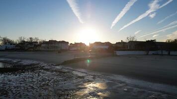 Serene Beachfront Houses at Sunrise with Reflecting Pools and Calm Waters. A tranquil sunrise beach scene with reflecting pools, sandy shoreline, and elegant beachfront houses. video