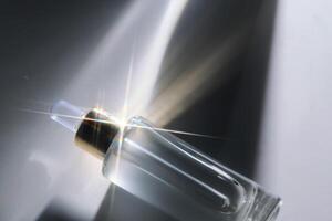 Bottle of face serum with a pipette with a beautiful highlight. photo