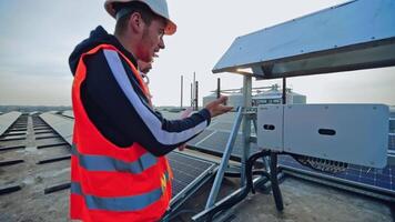 Innovative constructions for getting clean energy. Solar panel technicians working on a modern photovoltaic energy farm. video