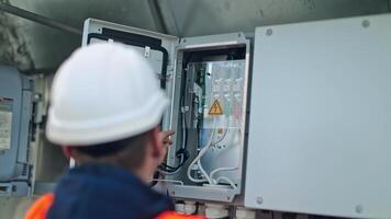 Electrician checks the wires of electric system. Male engineer controls the operation of the power system on a transformer. video