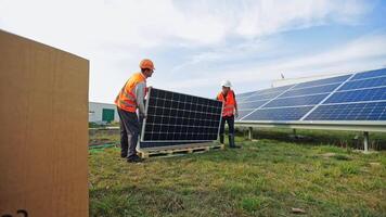 New solar panels on the grass. Workers installing photovoltaic panels for renewable energy. Construction of solar panels for new source of electricity. video