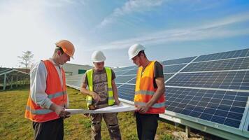 Installation of solar panels. Workers discussing the blueprint of new sunny cells. Engineers talking about photovoltaic panels on solar farm. video
