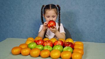 Portrait of a little girl with many fresh fruit. Ripe organic fruit nicely composed on the table and cute little girl playing with them. video