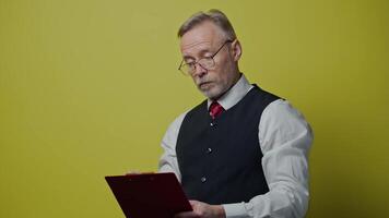 Thoughtful old businessman with a folder. Mature man becomes happy after finding the right solution to his project. Positive emotions. video