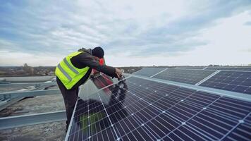 Technician installs solar battery. Workers installing new photovoltaic panels. Solar cells convert sunny energy into eco electric energy. video