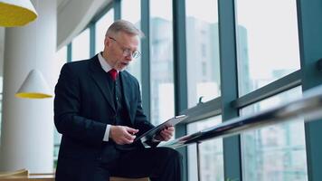 Angry businessman in the office. Mature man in elegant suit becomes nervous while working in his company. Senior entrepreneur with folder by the window. video