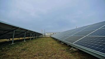 Engineers installing new solar panel. Workers in protective uniform put sunny battery on the metal basis in the solar farm. Alternative source of energy. video