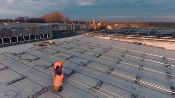 Installation of metal basis for solar panels on roof. Technicians installing new generation photovoltaic solar panels. Aerial view. video