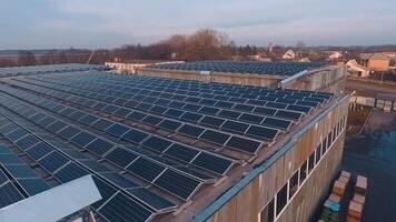 New solar station on the roof at sunset. Rows of solar panels on the rooftop of a big building in the countryside. Alternative source of energy. video