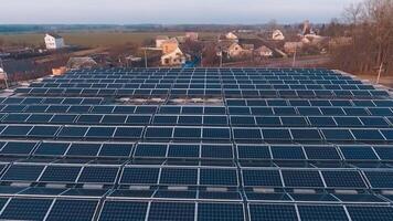 Solar energy farm on the roofs at sunset. Many solar panels on roofs of buildings in the countryside. Motion camera back. Aerial view. video