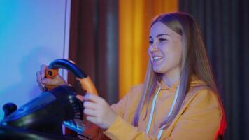 Portrait of a girl enjoying game on a computer. Smiling young woman playing games using a racing steering wheel. Entertainment concept. video