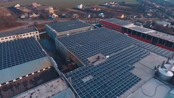 Solar farm on roofs of industrial buildings. Photovoltaic panels to get green alternative energy from the sunlight in the countryside. Aerial view. video