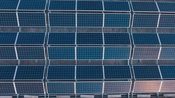 topo aéreo Visão do solar Fazenda em teto. ensolarado pilhas para renovável energia em a construção dentro a campo. alternativo energia. video