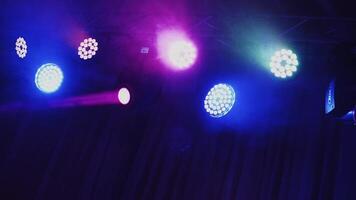 Stage light rack with colorful spotlights. Musical farm with lasers rotating and shining down in the concert hall. video