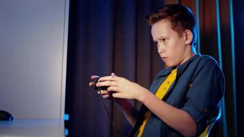 Side view of a boy playing games at home. Serious teenager plays game using joystick and becomes happy when he wins. video