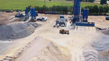 Modern asphalt plant among piles of rubble. Bulldozer working on the territory of asphalt factory. Aerial view. video