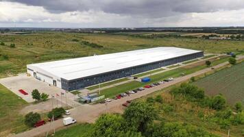 Exterior of newly built factory. View from the air on a modern manufacturing construction in the countryside in summer. Aerial view. Motion camera forward. video