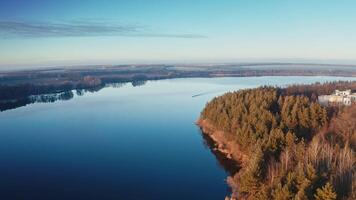 Calm lake in the evening. Boat moving on the river at sunset. Beautiful nature background. Trees reflected in water. Aerial view. video