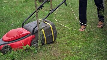 lawn mower at work on a green meadow at summertime video