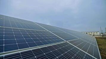 grandes ensolarado bateria em a campo. solar painel produz verde Claro energia a partir de a Sol. arranjo do solar energia Produção plantar. video