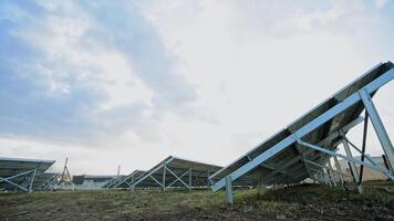 Inovativa solar Fazenda. metal construções com ensolarado pilhas em a chão. fotovoltaico solar painéis produzir alternativo energia. Visão a partir de abaixo. video
