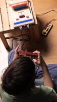 vertical Child playing with retro game console at home video