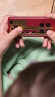 vertical criança jogando retro jogos com vermelho e ouro controlador video