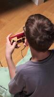 vertical Boy playing retro game console sitting on the floor video