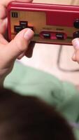 vertical Child playing retro games using controller at home video
