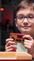 vertical Young boy playing with retro game console and holding joystick video