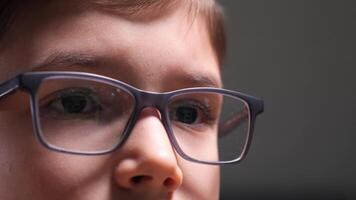 Child wearing eyeglasses and exploring digital world on computer screen video