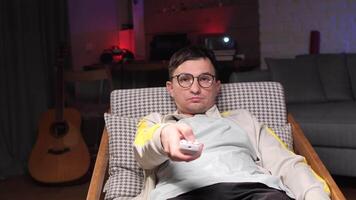 Man using remote control while relaxing on armchair at home video